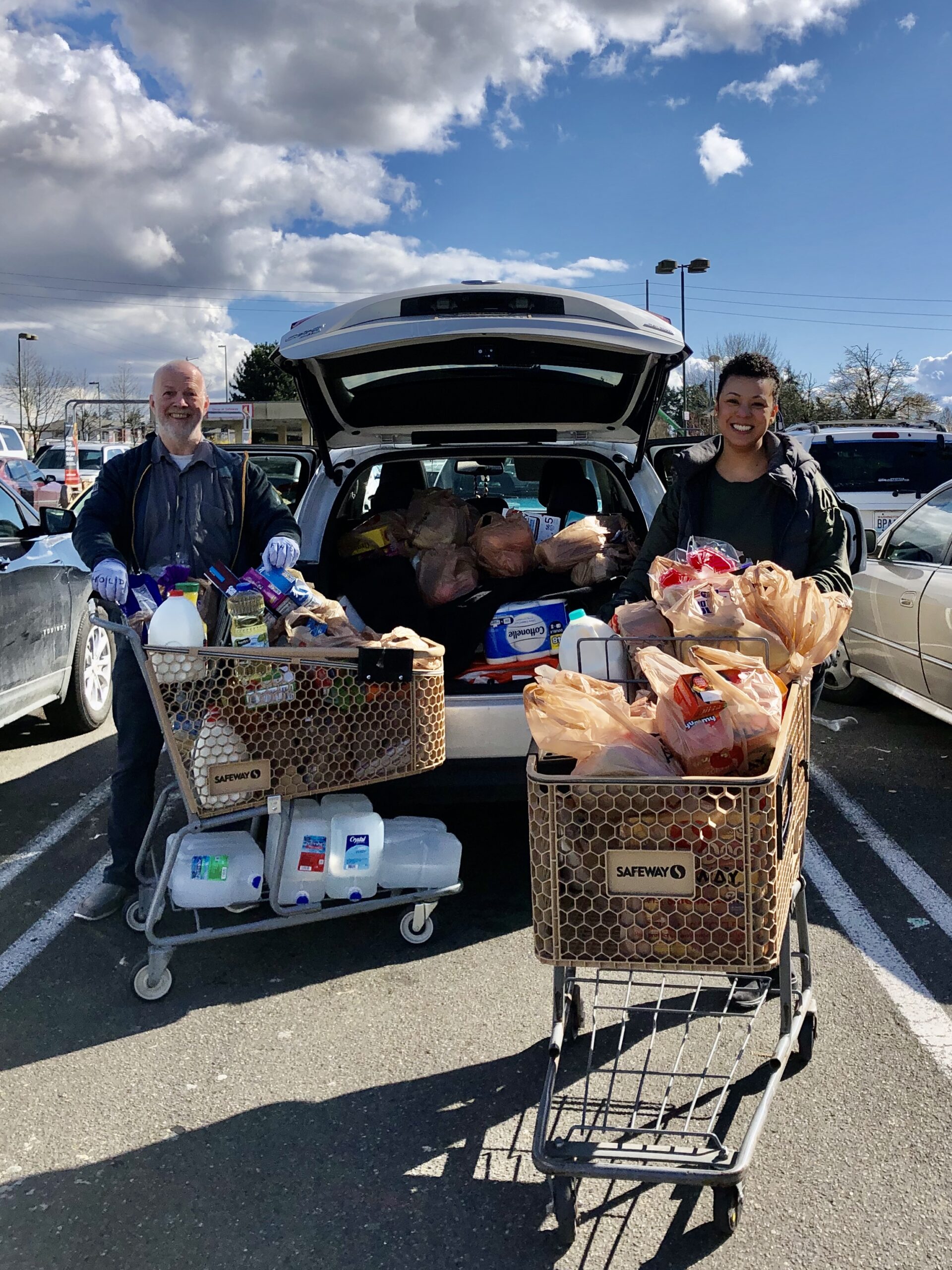 FEEST staff and volunteers stand with full grocery carts ready to give groceries to families in need